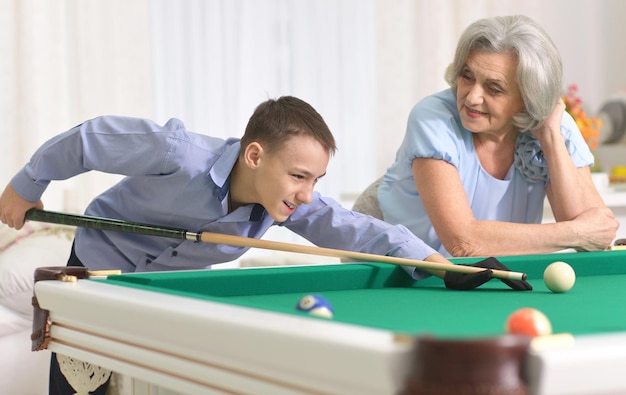 Femme mûre jouant au billard avec son petit-fils