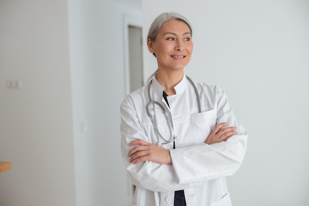 Femme mûre médecin debout dans le hall de l'hôpital