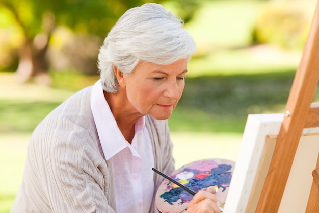 Femme mûre peinture dans le parc