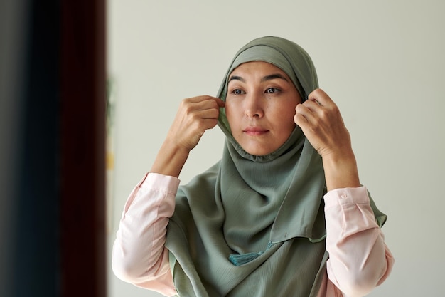 Une femme mûre portant le hijab avant de quitter la maison