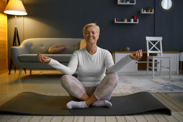 Femme mûre pratiquant le yoga en posture de lotus