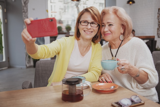 Femme mûre rencontre sa mère aînée au café