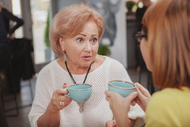 Femme mûre rencontre sa mère aînée au café