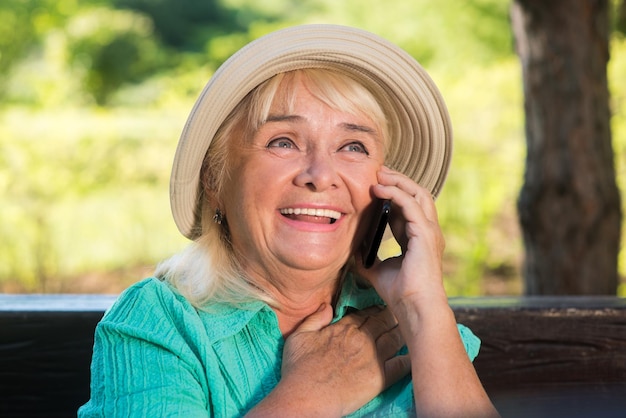 Femme mûre souriante avec téléphone