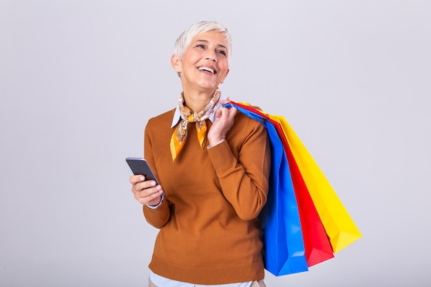 Femme mûre, tenue, sacs provisions, et, téléphone portable