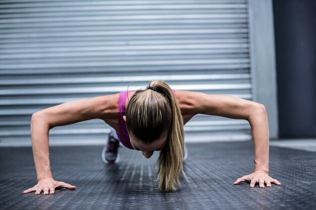 Photo femme musclée faisant des push ups