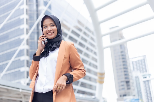 Femme musulmane d'affaires utilisant le téléphone en ville.