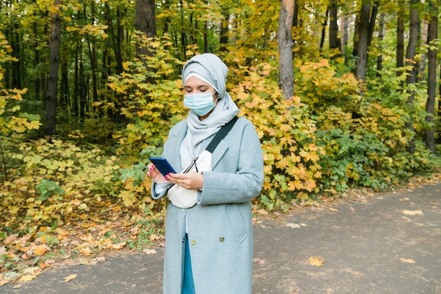Femme musulmane arabe portant un masque facial pour se protéger du coronavirus à l'extérieur