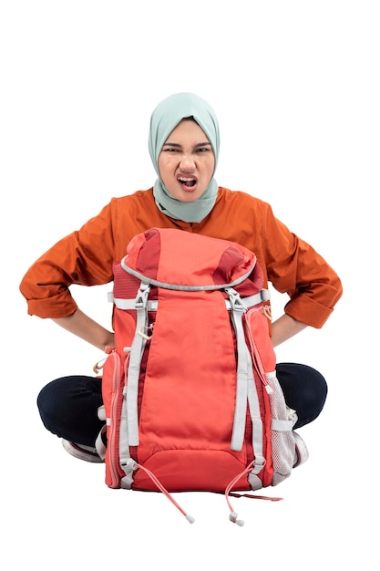 Femme musulmane asiatique dans un foulard assis avec un sac à dos avec une expression bouleversée