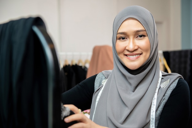 Femme musulmane asiatique dans son atelier de couture