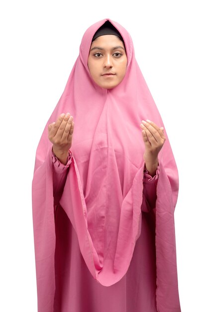 Femme musulmane asiatique dans un voile debout tandis que les mains levées et priant isolé sur fond blanc