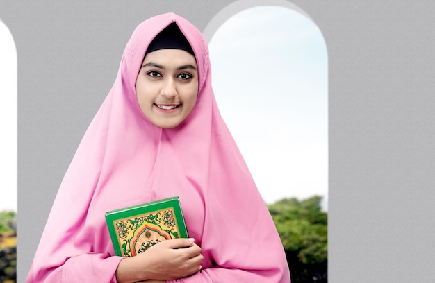 Femme musulmane asiatique dans un voile debout et tenant le Coran