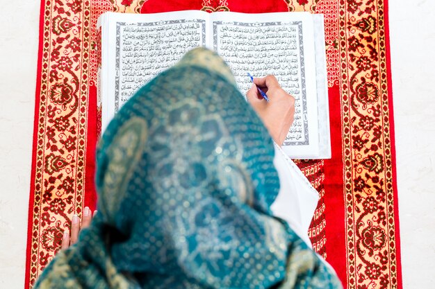 Femme musulmane asiatique étudiant le Coran ou le Coran