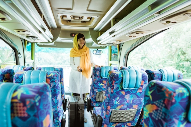 Femme musulmane asiatique faisant le voyage de retour dans sa ville natale en prenant un bus