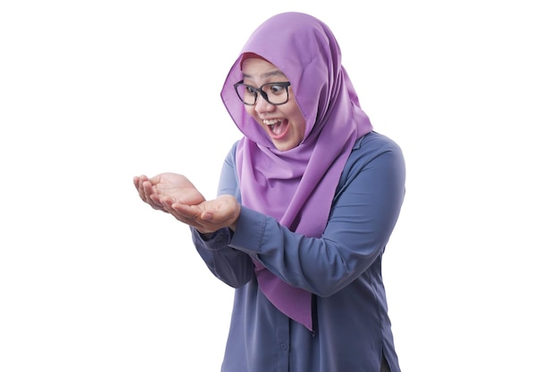 Une femme musulmane asiatique portant un hijab montre l'espace de copie la paume vide présentant quelque chose d'excité souriant
