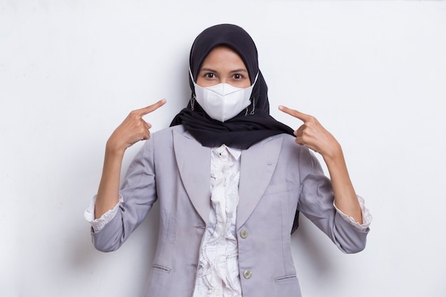 Femme musulmane asiatique portant un masque médical pour protéger le virus corona covid19 posant sur blanc