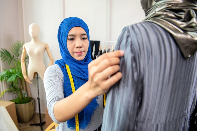 Femme musulmane asiatique travaillant dans son atelier de couture