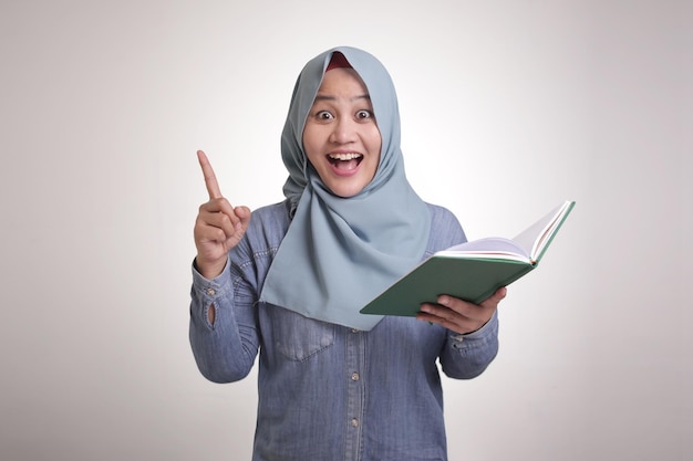 Femme musulmane ayant une bonne idée en lisant un livre