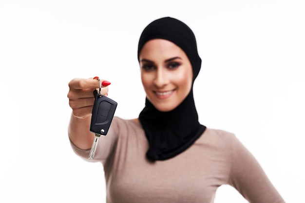 femme musulmane avec des clés de voiture sur blanc