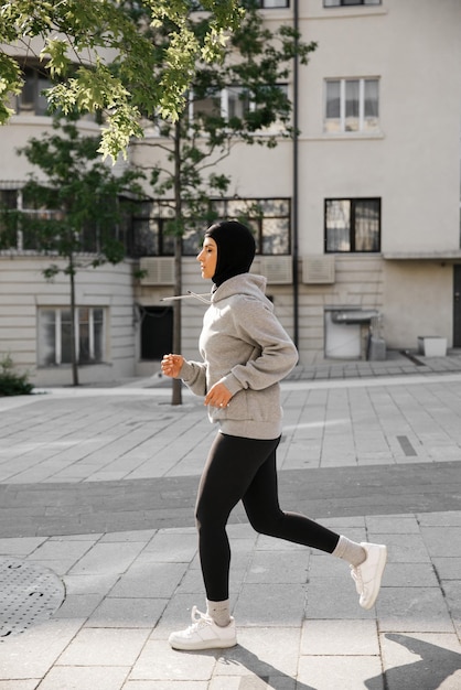 Femme musulmane en cours d'exécution sur l'entraînement en plein air du matin