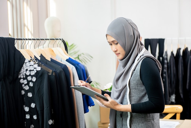 Femme musulmane designer travaillant dans un atelier de couture