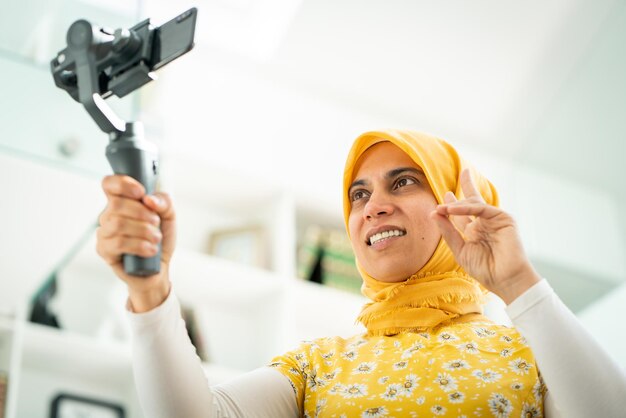 Femme musulmane diffusant du contenu vidéo en ligne à la maison