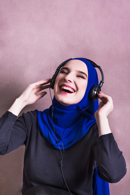 Femme musulmane écoutant de la musique sur des écouteurs