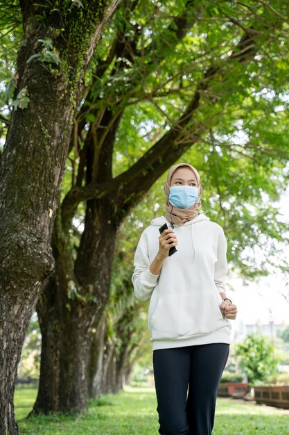 Femme musulmane faisant du sport et utilisant un masque en plein air pour empêcher la propagation du virus