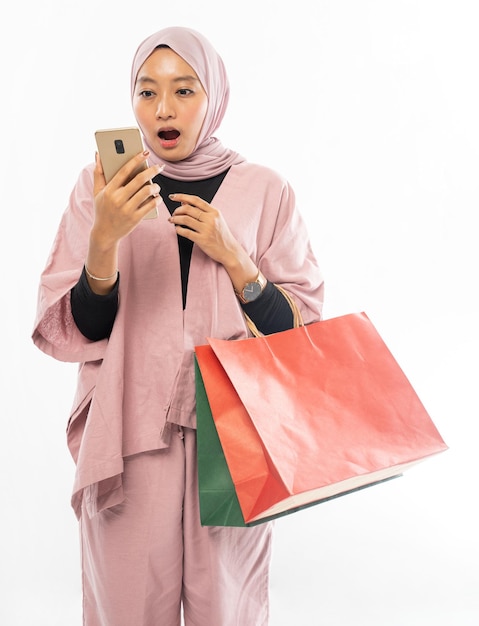 Une femme musulmane fait du shopping avec un téléphone portable ou un smartphone