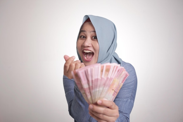Femme musulmane indonésienne tenant de l'argent Rupiah