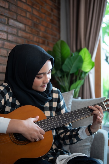 Femme musulmane jouant de la guitare