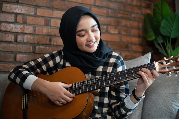 Femme musulmane jouant de la guitare