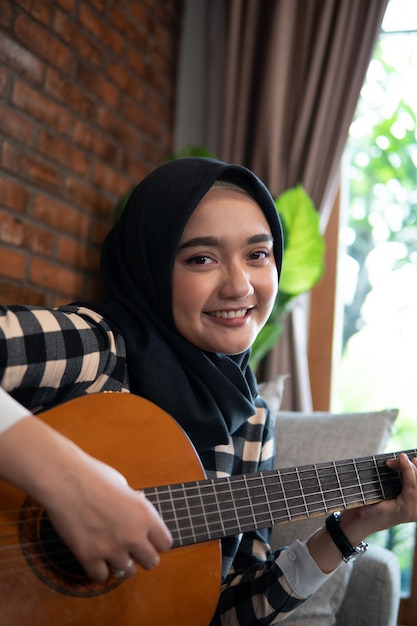 Femme musulmane jouant de la guitare