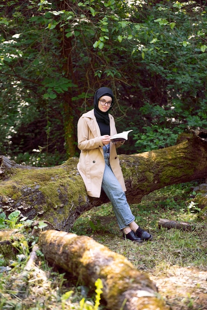 Femme musulmane lisant un livre dans le parc pendant son temps libre