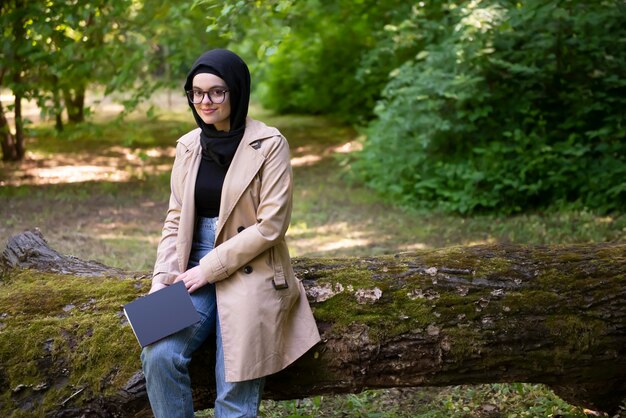 Femme musulmane lisant un livre dans le parc pendant son temps libre