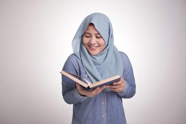 Femme musulmane lisant un livre souriant
