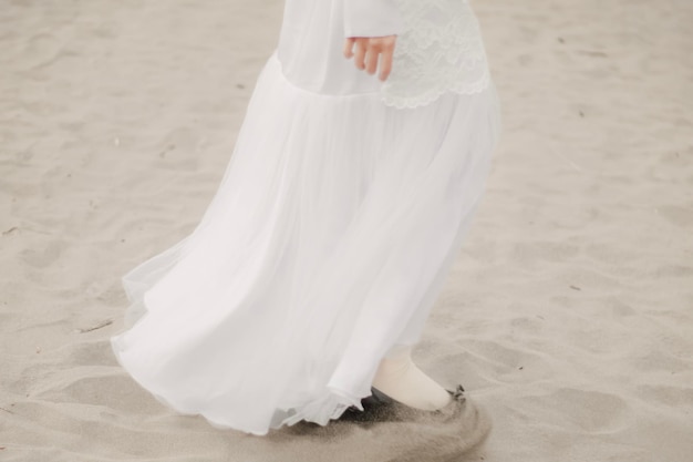 Une femme musulmane marche le long du sable et de la mer Un modèle de fille utilisant le hijab s'amusant à la plage