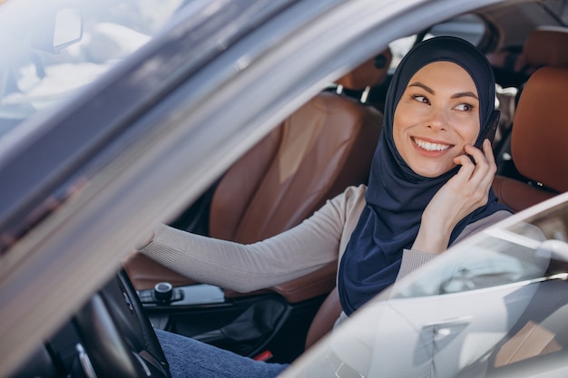 Femme musulmane parlant au téléphone dans sa voiture