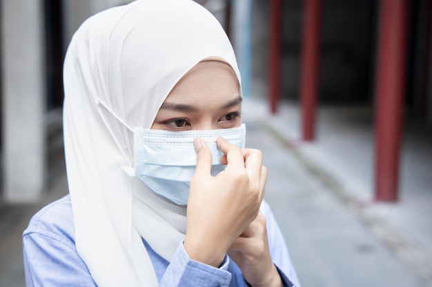 Femme musulmane portant un masque facial dans un concept public extérieur de nouveau mode de vie normal distanciation sociale aplatir la mesure préventive de la courbe contre la pandémie de grippe