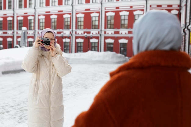 Photo femme musulmane prenant une photo de son amie pendant ses vacances