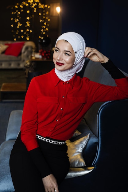 Femme musulmane près de la décoration de Noël en studio. Modèle musulman professionnel posant à la veille du nouvel an