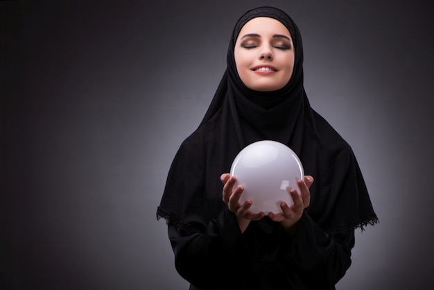 Femme musulmane en robe noire sur fond sombre