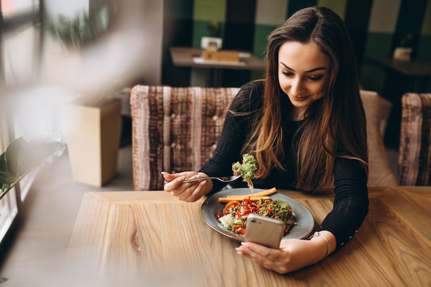 Femme musulmane avec salade parlant au téléphone