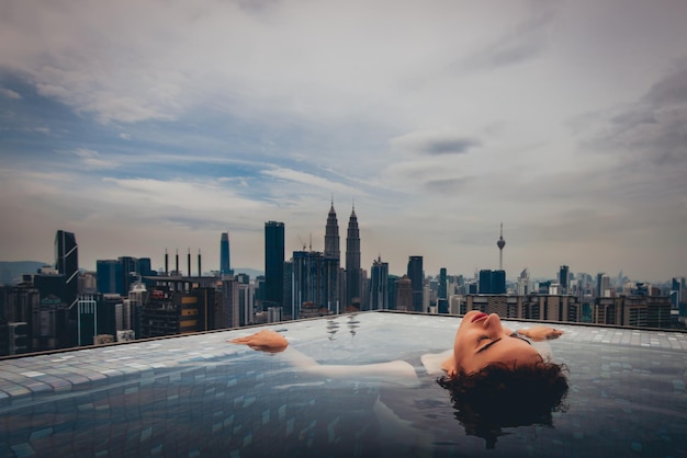 Une femme nageant dans une piscine à l'infini.