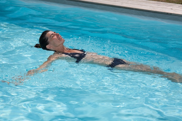femme nageant dans une piscine privée en été