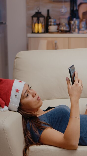 Femme naviguant sur Internet sur smartphone et regardant la télévision