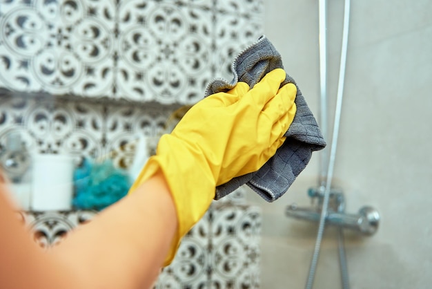 Photo une femme nettoie la cabine de la salle de bain.