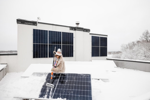 Photo une femme nettoie les panneaux solaires de la neige