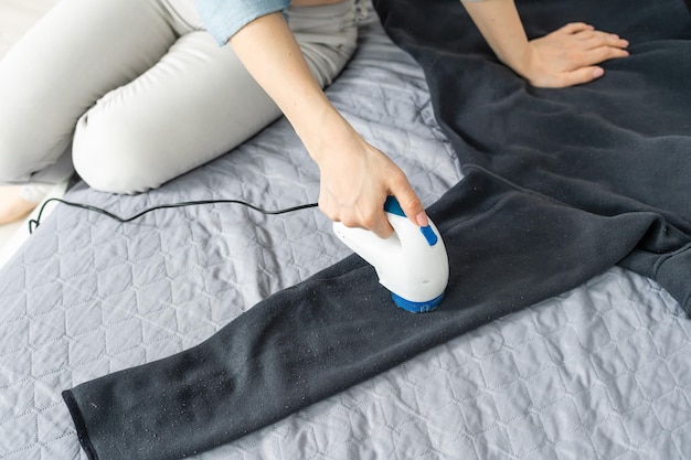 Une femme nettoie les vêtements d'une bobine avec un dissolvant de granulés de près.