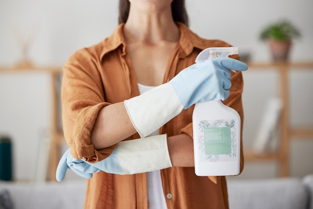 Femme nettoyage de printemps et flacon pulvérisateur avec les bras croisés pour l'assainissement ménager ou la désinfection des bactéries de la saleté et de la poussière à la maison Gros plan produit nettoyant chimique et entretien de la maison